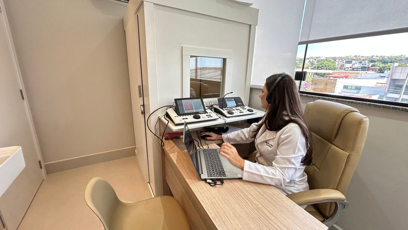 Sala de audiometria com profissional em atendimento