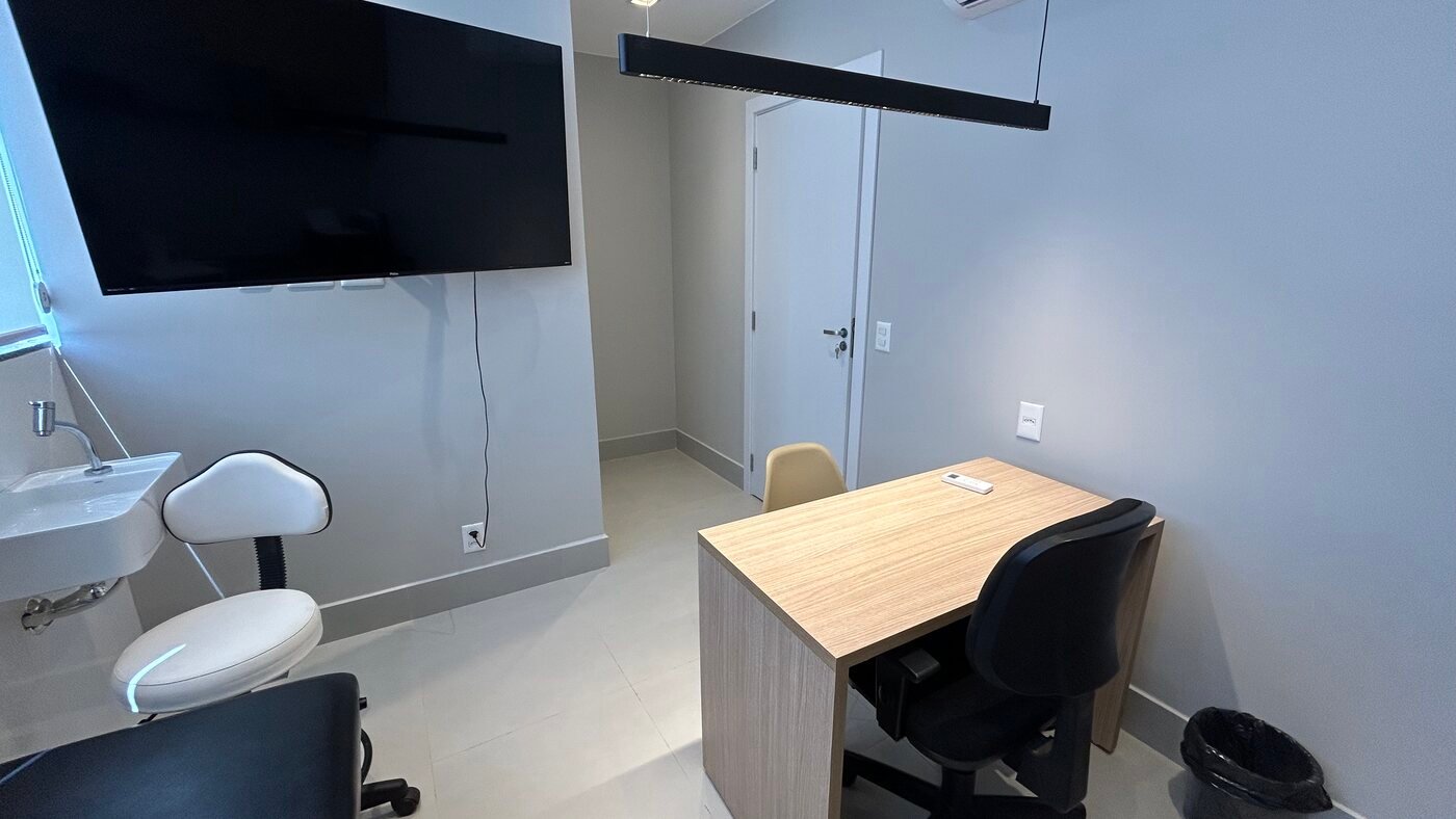 Sala de atendimento com maca e estação de trabalho